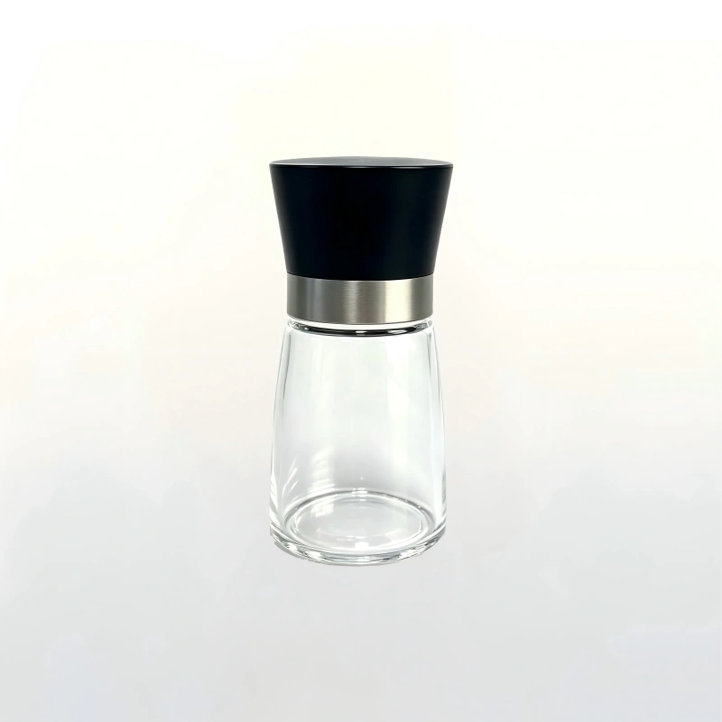 Transparent spice bottle with black plastic grinder top and stainless steel ring