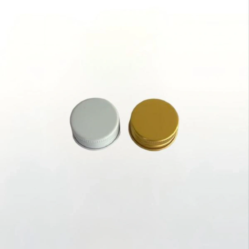 Pair of metallic silver and gold aluminum screw lids with ribbed caps for clear glass beverage bottles.